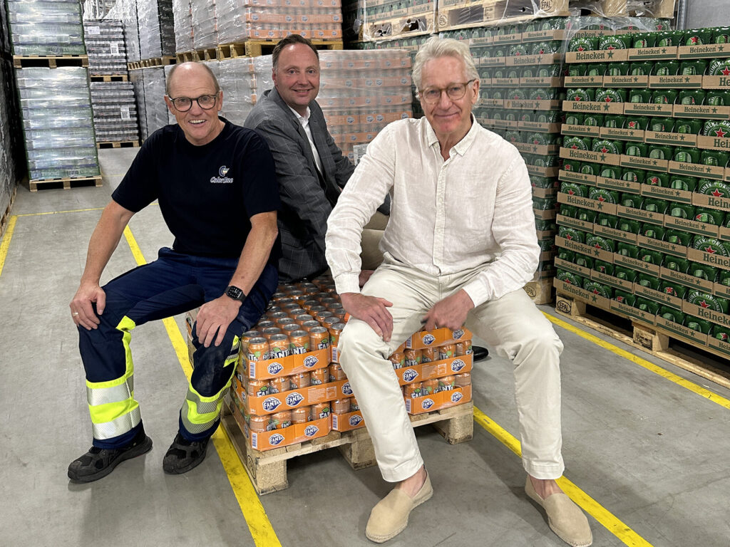 Brian Ejsing, Kim Vrist og Olav Nils blant paller med forfriskende drikker på logistikksenteret.